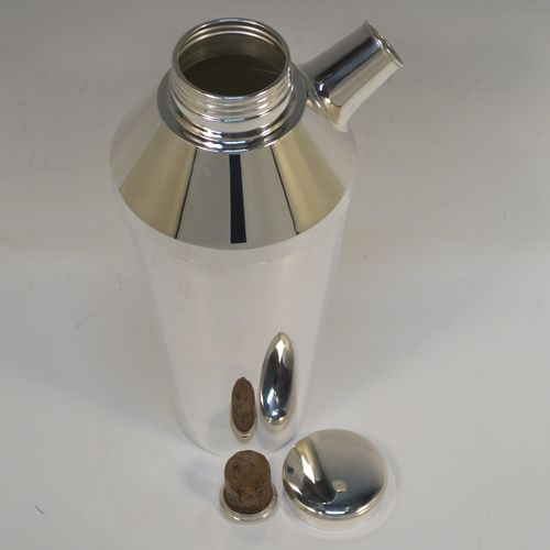 A very elegant Art Deco style Silver-Plated cocktail shaker, having a plain round body with tapering sides, with a screw-off top lid and a pull-off side pouring cap with cork stopper. This handsome silver-plated cocktail shaker was made in ca. 1930. The dimensions of this fine hand-made silver plated cocktail shaker are height 25 cms (9.75 inches), and diameter at widest point 10 cms (4 inches).   