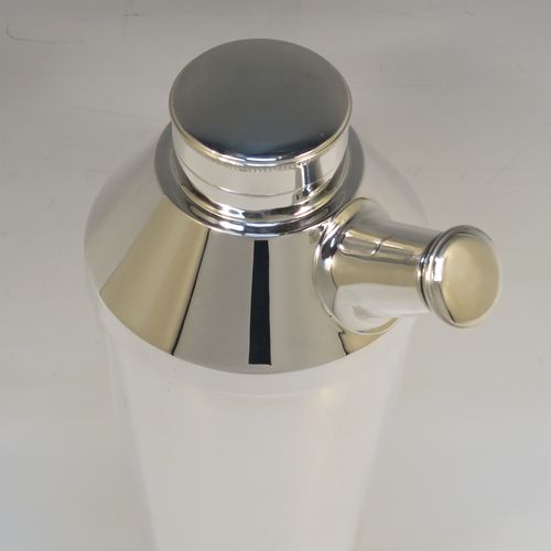 A very elegant Art Deco style Silver-Plated cocktail shaker, having a plain round body with tapering sides, with a screw-off top lid and a pull-off side pouring cap with cork stopper. This handsome silver-plated cocktail shaker was made in ca. 1930. The dimensions of this fine hand-made silver plated cocktail shaker are height 25 cms (9.75 inches), and diameter at widest point 10 cms (4 inches).   