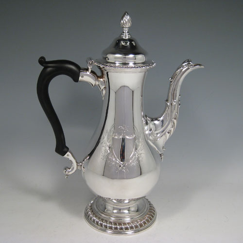 Antique Georgian sterling silver baluster style large coffee pot with gadroon edges, wooden scroll handle, flame knop finial, and anthemion leaf decorated spout. Made by Francis Butty and Nicholas Dummee of London in 1772. Height 30 cms (11.75 inches), length 21.5 cms (8.5 inches). Weight approx. 28 troy ounces (868g). Please note that this item is crested on both sides of the main body.