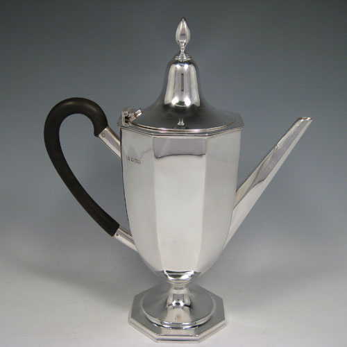 A Sterling Silver large sized fine hand-made panelled coffee pot with plain panelled body, a hinged lid with finial, a curved wooden handle, and all sitting on a pedestal foot. Made by William Bush of Sheffield in 1932. The dimensions of this fine silver coffee pot are length 24 cms (9.5 inches), height 29 cms (11.5 inches), and it weighs approx. 682g (22 troy ounces).