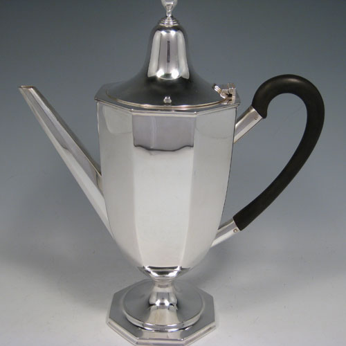 A Sterling Silver large sized fine hand-made panelled coffee pot with plain panelled body, a hinged lid with finial, a curved wooden handle, and all sitting on a pedestal foot. Made by William Bush of Sheffield in 1932. The dimensions of this fine silver coffee pot are length 24 cms (9.5 inches), height 29 cms (11.5 inches), and it weighs approx. 682g (22 troy ounces).