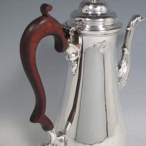 Antique Georgian sterling silver coffee pot, having a plain round baluster body, a domed hinged lid with acorn finial, a scroll spout, and a scrolled wooden handle, sitting on a round pedestal foot. Made by John Mackfarlen (Poss.) of London in 1759. The dimensions of this fine hand-made silver coffee pot are length 20 cms (8 inches), height 26 cms (10.25 inches), and it weighs approx. 800g (26 troy ounces).   