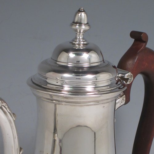 Antique Georgian sterling silver coffee pot, having a plain round baluster body, a domed hinged lid with acorn finial, a scroll spout, and a scrolled wooden handle, sitting on a round pedestal foot. Made by John Mackfarlen (Poss.) of London in 1759. The dimensions of this fine hand-made silver coffee pot are length 20 cms (8 inches), height 26 cms (10.25 inches), and it weighs approx. 800g (26 troy ounces).   