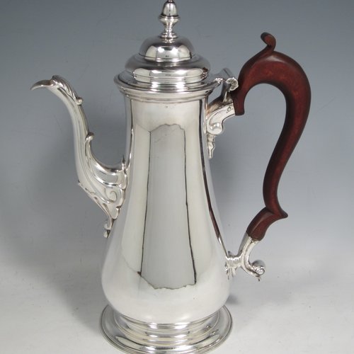 Antique Georgian sterling silver coffee pot, having a plain round baluster body, a domed hinged lid with acorn finial, a scroll spout, and a scrolled wooden handle, sitting on a round pedestal foot. Made by John Mackfarlen (Poss.) of London in 1759. The dimensions of this fine hand-made silver coffee pot are length 20 cms (8 inches), height 26 cms (10.25 inches), and it weighs approx. 800g (26 troy ounces).   