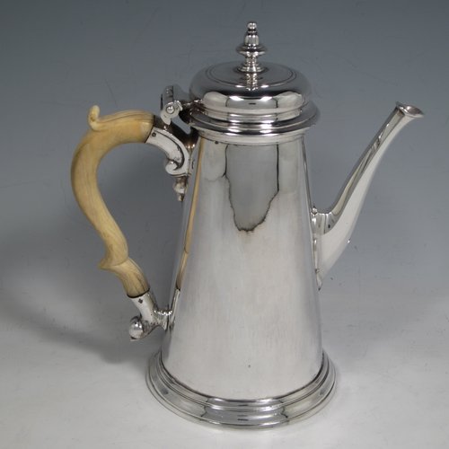 Antique Georgian sterling silver George II coffee pot, having a plain round body with straight tapering sides, a hinged cushion style lid with finial, an octagonal panelled spout, an ivory scroll handle, and all sitting on a collet foot. Made by John Swift of London in 1738. The dimensions of this fine hand-made silver coffee pot are length 18 cms (7 inches), height 20 cms (8 inches), and it weighs approx. 625g (20 troy ounces). Please note that this item shows fire-stain which is acceptable for a piece from this period.