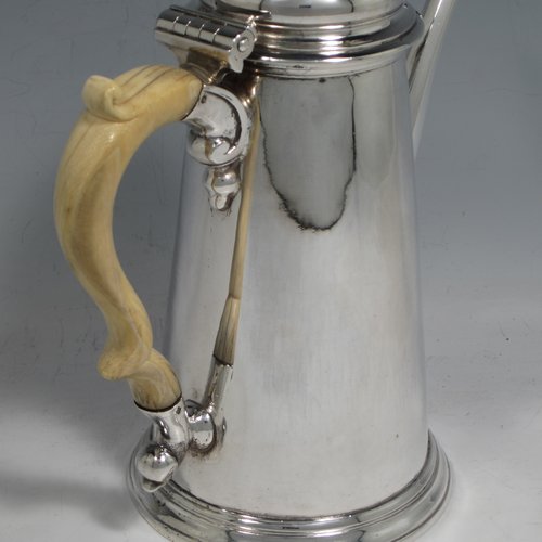 Antique Georgian sterling silver George II coffee pot, having a plain round body with straight tapering sides, a hinged cushion style lid with finial, an octagonal panelled spout, an ivory scroll handle, and all sitting on a collet foot. Made by John Swift of London in 1738. The dimensions of this fine hand-made silver coffee pot are length 18 cms (7 inches), height 20 cms (8 inches), and it weighs approx. 625g (20 troy ounces). Please note that this item shows fire-stain which is acceptable for a piece from this period.