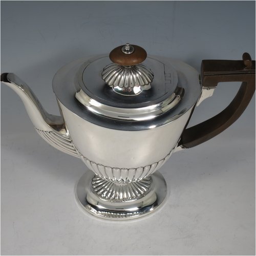 An Antique Victorian Sterling Silver coffee pot, in a Queen Anne style, having an oval tapering body with hand-chased half-fluted decoration, a wooden handle, a hinged lid with an invisible flat hinge and wooden finial, and all sitting on a pedestal foot. Made by Charles Stuart Harris of London in 1885. The dimensions of this fine hand-made antique silver coffee pot are length 22 cms (8.5 inches), height 21 cms (8.25 inches), and it weighs approx. 340g (11 troy ounces).   