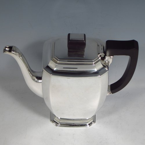 A Sterling silver Art Deco style coffee pot, having very plain panelled body with tapering sides, a wooden handle, a hinged lid with matching finial, and all sitting on a collet foot. Made by Mappin & Webb of Sheffield in 1950. The dimensions of this fine hand-made silver coffee pot are length 20 cms (8 inches), height 19 cms (7.5 inches), and it weighs approx. 600g (19.4 troy ounces).   