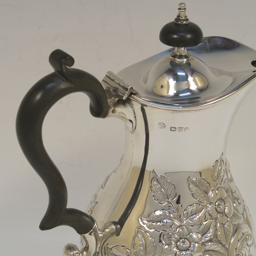 A small but very pretty Antique Victorian  Sterling Silver coffee pot, having a round hand-chased bellied body with hand-chased floral decoration, a domed hinged lid with a wooden finial, a matching black-stained wooden scroll handle, and all sitting on three cast feet with floral shoulders. This beautiful small silver coffee pot was made by William Aitken of Chester in 1899. The dimensions of this fine hand-made antique silver coffee pot are height 17 cms (6.75 inches), length 14 cms (5.5 inches), and it weighs approx. 350g (11 troy ounces).   