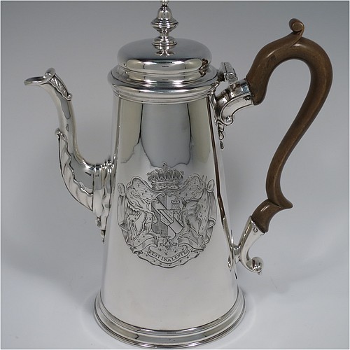 An Antique Georgian Sterling Silver George II coffee pot, having a plain round body with straight tapering sides, a hinged cushion style lid with cast finial, a curved spout with an applied anthemion leaf, a hand-carved wooden scroll handle, and all sitting on a collet foot. Made by Edward Vincent of London in 1738. The dimensions of this fine hand-made antique silver coffee pot are length 21 cms (8.25 inches), height 23.5 cms (9.25 inches), and it weighs approx. 845g (27 troy ounces). Please note that this item is engraved with a full armorial crest on one side.   