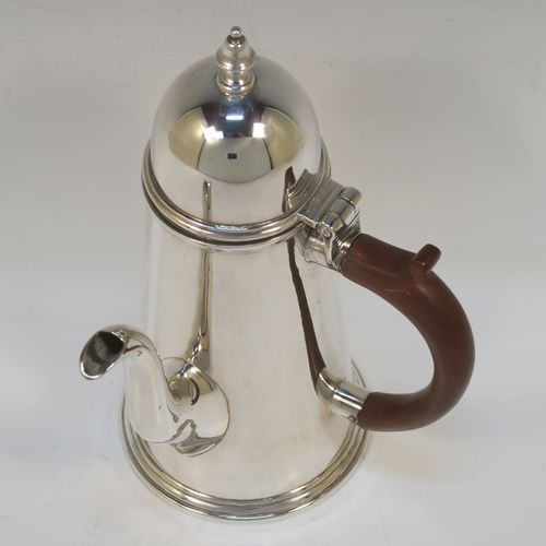 A very handsome Antique Sterling Silver George I style side-handled coffee pot, having a plain round body with straight tapering sides, a hinged domed lid with cast urn-shaped finial, a curved  spout, a hand-carved brown-stained wooden scroll handle, and all sitting on a collet foot. This elegant silver coffee-pot was made by P and F of Sheffield in 1917. The dimensions of this fine hand-made antique silver side-handled coffee pot are length 12.5 cms (5 inches), height 21.5 cms (8.5 inches), and it weighs approx. 465g (15 troy ounces).  