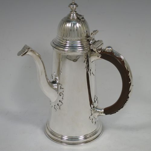 A very unusual and fine pair of Sterling Silver Queen Anne style side-handled coffee or chocolate pots, having plain round bodies with straight tapering sides and applied cut-card work, hinged domed lids with cast thumb-pieces and hinged finials to allow the use of a chocolate stirring spoons, curved spouts with hinged openings, hand-carved wooden scroll handles with applied silver mounts, and all sitting on round collet feet. Made by Heming and Co., of London in 1932. The dimensions of this fine hand-made pair of silver chocoloate or coffee pots are length 16.5 cms (6.5 inches), height 23 cms (9 inches), and they weigh a total of approx. 1,302g (42 troy ounces).   