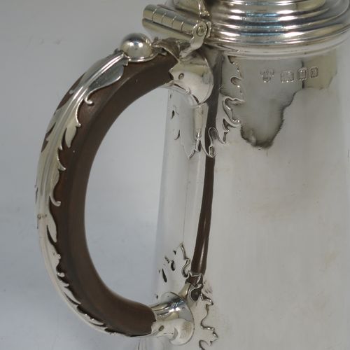 A very unusual and fine pair of Sterling Silver Queen Anne style side-handled coffee or chocolate pots, having plain round bodies with straight tapering sides and applied cut-card work, hinged domed lids with cast thumb-pieces and hinged finials to allow the use of a chocolate stirring spoons, curved spouts with hinged openings, hand-carved wooden scroll handles with applied silver mounts, and all sitting on round collet feet. Made by Heming and Co., of London in 1932. The dimensions of this fine hand-made pair of silver chocoloate or coffee pots are length 16.5 cms (6.5 inches), height 23 cms (9 inches), and they weigh a total of approx. 1,302g (42 troy ounces).   