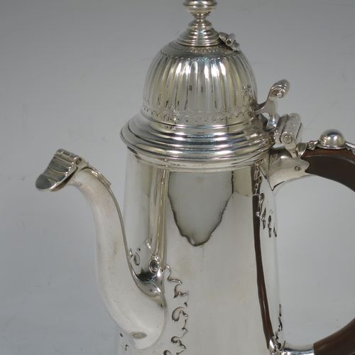 A very unusual and fine pair of Sterling Silver Queen Anne style side-handled coffee or chocolate pots, having plain round bodies with straight tapering sides and applied cut-card work, hinged domed lids with cast thumb-pieces and hinged finials to allow the use of a chocolate stirring spoons, curved spouts with hinged openings, hand-carved wooden scroll handles with applied silver mounts, and all sitting on round collet feet. Made by Heming and Co., of London in 1932. The dimensions of this fine hand-made pair of silver chocoloate or coffee pots are length 16.5 cms (6.5 inches), height 23 cms (9 inches), and they weigh a total of approx. 1,302g (42 troy ounces).   