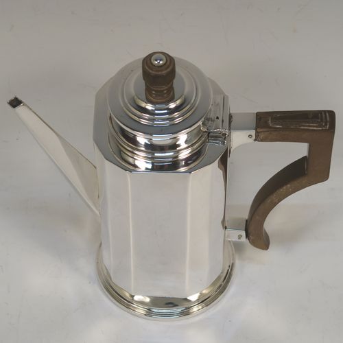 A very elegant Art Deco style Sterling Silver bachelor size coffee pot, having a straight-sided panelled body, a brown wooden side-handle with stepped thumb-piece, a stepped hinged lid with wooden finial, a straight panelled spout, and all sitting on a collet foot. This beautiful silver Art Deco coffee pot was made by Charles S. Green & Co. Ltd., of Birmingham in 1933. This Art Deco coffee pot would be suitable for serving two people and the dimensions of this fine hand-made silver coffee pot are length 16 cms (6.25 inches), height 16.5 cms (6.5 inches), and it weighs approx. 280g (9 troy ounces).  