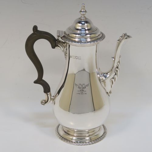 A handsome Antique Edwardian Sterling Silver small coffee pot for two people, having a plain round bellied body with applied gadroon borders, a brown wooden scroll side-handle, a hinged domed lid with cast finial, and all sitting on a pedestal foot. This elegant silver coffee pot was made by Charles Stuart Harris of London in 1906. The dimensions of this fine hand-made antique sterling silver small coffee pot are height 20 cms (8 inches), length 15 cms (6 inches), and it weighs approx. 300g (9.7 troy ounces).   