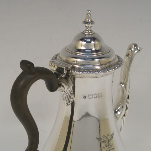 A handsome Antique Edwardian Sterling Silver small coffee pot for two people, having a plain round bellied body with applied gadroon borders, a brown wooden scroll side-handle, a hinged domed lid with cast finial, and all sitting on a pedestal foot. This elegant silver coffee pot was made by Charles Stuart Harris of London in 1906. The dimensions of this fine hand-made antique sterling silver small coffee pot are height 20 cms (8 inches), length 15 cms (6 inches), and it weighs approx. 300g (9.7 troy ounces).   