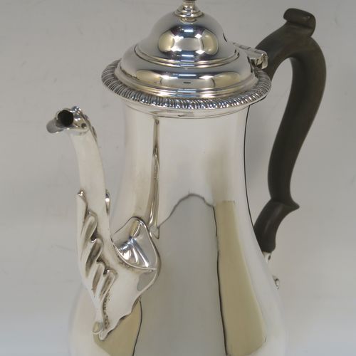 A handsome Antique Edwardian Sterling Silver small coffee pot for two people, having a plain round bellied body with applied gadroon borders, a brown wooden scroll side-handle, a hinged domed lid with cast finial, and all sitting on a pedestal foot. This elegant silver coffee pot was made by Charles Stuart Harris of London in 1906. The dimensions of this fine hand-made antique sterling silver small coffee pot are height 20 cms (8 inches), length 15 cms (6 inches), and it weighs approx. 300g (9.7 troy ounces).   