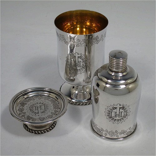 A very unusual and handsome Antique Victorian Silver Plated three-piece travelling communion set consisting of a chalice, paten, and wine bottle. The chalice having a round body with a gold-gilt interior, and sitting on a pedestal foot with a gadroon border. The paten having a round body sitting on a pedestal foot with a gadroon border. The wine bottle having a round body with a flat base and screw-off corked lid. All three pieces are hand-engraved with Christograms and a band of grapevine decoration, and sit in their original dark blue velvet-lined presentation box. All made in ca. 1848, with a contemporaneous inscription on the chalice. The dimensions of this fine hand-made antique silver-plated travelling communion set are height of chalice 10 cms (4 inches), diameter of paten 6.5 cms (2.5 inches), and height of bottle 9.5 cms (3.75 inches).