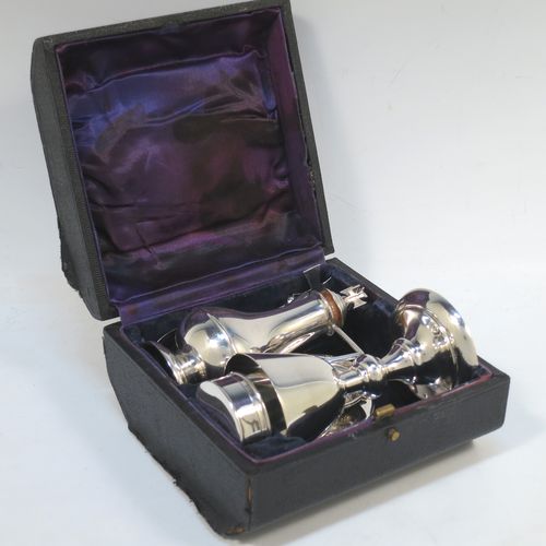 A Sterling Silver five-piece travelling communion set consisting of chalice, paten, anointing spoon, wine bottle, and pyx box. The chalice having a plain round body, and sitting on a pedestal foot. The paten having a plain round body, and sitting on a collet foot. The wine bottle having a plain round body with pull-off lid, and a cork seal. The anointing spoon having a plain oval bowl and cruciform finial. The pyx box having a plain round body with pull-off lid. All sitting in their original dark blue satin and velvet-lined presentation box. Made by Elkington and Co., of Birmingham in 1934. The dimensions of this fine hand-made silver travelling communion set are height of chalice 9.5 cms (3.75 inches), diameter of paten 8 cms (3.25 inches), length of spoon 11 cms (4.25 inches), and with a total weight of approx. 214g (6.9 troy ounces).  