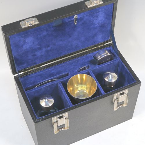 An elegant and complete Sterling Silver six-piece travelling communion set consisting of chalice, paten, water, and wine bottles, a wafer pyx box, and an anointing spoon. The chalice having a plain round body with tapering sides, a gold-gilt interior, and sitting on a round pedestal foot. The paten and pyx box having plain round bodies. The wine and water bottles having plain round screw-off lids, cork seals, and hand-cut crystal bodies. All sitting in their original dark blue satin and velvet-lined presentation box with secure catches and carrying handle (the lid having an extra folding compartment). This beautiful communion set was all made by Wippell Mowbray Church Furnishers Ltd., of London in 1972. The dimensions of this fine hand-made silver travelling communion set are height of chalice 9 cms (3.5 inches), diameter of paten 8.5 cms (3.3 inches), and with a total weight of approx. 200g (6.5 troy ounces).