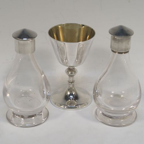 An elegant and complete Sterling Silver six-piece travelling communion set consisting of chalice, paten, water, and wine bottles, a wafer pyx box, and an anointing spoon. The chalice having a plain round body with tapering sides, a gold-gilt interior, and sitting on a round pedestal foot. The paten and pyx box having plain round bodies. The wine and water bottles having plain round screw-off lids, cork seals, and hand-cut crystal bodies. All sitting in their original dark blue satin and velvet-lined presentation box with secure catches and carrying handle (the lid having an extra folding compartment). This beautiful communion set was all made by Wippell Mowbray Church Furnishers Ltd., of London in 1972. The dimensions of this fine hand-made silver travelling communion set are height of chalice 9 cms (3.5 inches), diameter of paten 8.5 cms (3.3 inches), and with a total weight of approx. 200g (6.5 troy ounces).