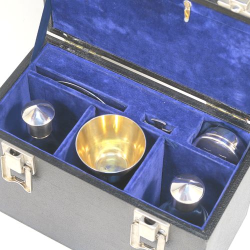 An elegant and complete Sterling Silver six-piece travelling communion set consisting of chalice, paten, water, and wine bottles, a wafer pyx box, and an anointing spoon. The chalice having a plain round body with tapering sides, a gold-gilt interior, and sitting on a round pedestal foot. The paten and pyx box having plain round bodies. The wine and water bottles having plain round screw-off lids, cork seals, and hand-cut crystal bodies. All sitting in their original dark blue satin and velvet-lined presentation box with secure catches and carrying handle (the lid having an extra folding compartment). This beautiful communion set was all made by Wippell Mowbray Church Furnishers Ltd., of London in 1972. The dimensions of this fine hand-made silver travelling communion set are height of chalice 9 cms (3.5 inches), diameter of paten 8.5 cms (3.3 inches), and with a total weight of approx. 200g (6.5 troy ounces).