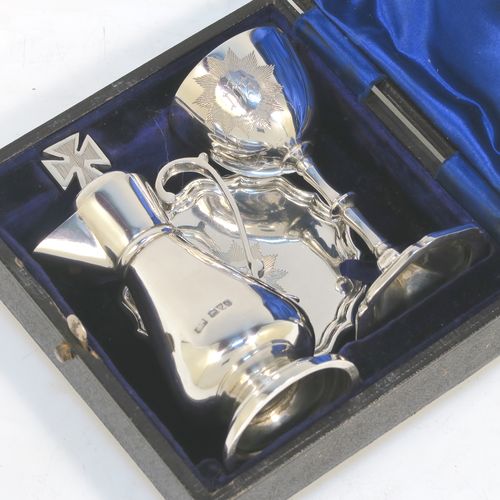 A very elegant Antique Edwardian Sterling Silver three-piece travelling communion set consisting of chalice, paten, and wine ewer. The chalice having a plain round bellied body, a gold-gilt interior, and sitting on a pedestal foot. The paten having a round body with an applied Chippendale border, and sitting on a pedestal foot. The wine ewer having a plain bellied body, a pull-off top with cork stopper and cruciform finial, a scroll side-handle, and sitting on a pedestal foot. All three pieces are hand-engraved with an IHS Christogram, and they are all sitting in their original dark blue satin and velvet-lined presentation box. This beautiful communion service was made by Charles Cook of Chester in 1905. The dimensions of this fine hand-made antique silver travelling communion set are height of chalice 8.5 cms (3.3 inches), diameter of paten 7 cms (2.75 inches), height of wine ewer 11 cms (4.25 inches), and with a total weight of approx. 160g (5.2 troy ounces). Please note that the paten has a contemporaneous presentation inscription underneath.