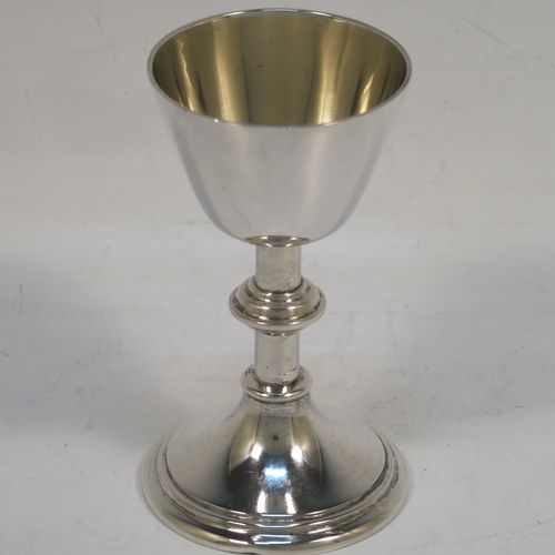 A handsome Antique Sterling Silver small travelling communion chalice, having a plain round tapering cup with a lemon gold-gilt interior, a middle plain round baluster, and sitting on a round pedestal foot. This beautiful silver chalice was made by Frederick Dendy Wray of London in 1914. The dimensions of this fine hand-made silver chalice are  height 9 cms (3.5 inches), diameter of cup 5 cms (2 inches), and a weight of approx. 69g (2.2 troy ounces).   