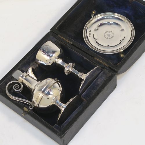 A very handsome Antique Victorian Sterling Silver three-piece travelling communion set consisting of chalice, paten, and wine ewer. The chalice having a plain round bellied body with a hexagonal stem and shaped round pedestal foot. The paten having a round body with an applied reeded border, and sitting on a flat base. The wine ewer having a plain bellied body, a pull-off top with cork stopper and cruciform finial, a scroll side-handle, and sitting on a matching pedestal foot. All three pieces are hand-engraved with an IHS Christogram, and they are all sitting in their original dark blue velvet-lined presentation box which has a contemporaneous presentation inscription on a brass plaque. This beautiful communion service was all made by Walker and Hall of Sheffield in 1896. The dimensions of this fine hand-made antique silver travelling communion set are height of chalice 9 cms (3.5 inches), diameter of paten 8.5 cms (3.3 inches), height of wine ewer 10.5 cms (4 inches), and with a total weight of approx. 238g (7.7 troy ounces). 