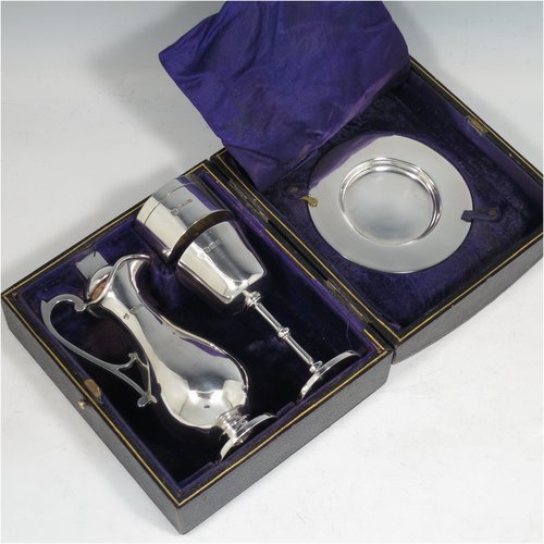 An Antique Sterling Silver four-piece travelling communion set consisting of chalice, paten, wine flagon, and pyx box. In a very plain round style, having a gold-gilt interior to the chalice, a pull-off lid with cork on the flagon, and a pull-off lid for the pyx box. All the pieces sit in their original blue velvet-lined presentation box which has an applied inscription attached to the top of the lid. Made by Martin Hall & Co., of Sheffield in 1912. The dimensions of this fine hand-made antique silver travelling communion set are height of flagon 13 cms (5 inches), diameter of paten 9 cms (3.5 inches), and with a total weight of approx. 254g (8.2 troy ounces).   