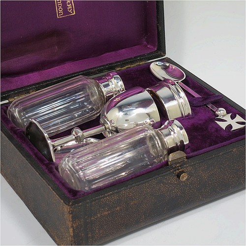 A complete Antique Sterling Silver six-piece travelling communion set consisting of chalice, paten, water, and wine bottles, a wafer pyx box, and an anointing spoon. The chalice having a plain round body with gold-gilt interior, and sitting on a round pedestal foot. The paten and pyx box having plain round bodies. The wine and water bottles having plain round screw-off lids, cork seals, and hand-cut crystal bodies. All hand-engraved with Christograms and sitting in their original purple satin and velvet-lined presentation box. All made by Frederick Dendy Wray of London in 1913. The dimensions of this fine hand-made antique silver travelling communion set are height of chalice 8.5 cms (3.3 inches), diameter of paten 5.5 cms (2.25 inches), and with a total weight of approx. 125g (4 troy ounces). Please note that the box lid exterior is monogrammed with a set of contemporaneous initials.   