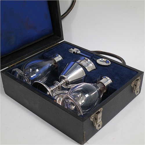 A Sterling Silver six-piece travelling communion set consisting of chalice, paten, water, and wine bottles, a wafer pyx box, and an anointing spoon. The chalice having a plain round body with tapering sides, and sitting on a round pedestal foot. The paten and pyx box having plain round bodies. The wine and water bottles having plain round screw-off lids, cork seals, and hand-cut crystal bodies. All sitting in their original dark blue satin and velvet-lined presentation box, which also has a concealed compartment for sacramental cloth and wafers. All made by H. F. and Co. Ltd., of London in 1966. The dimensions of this fine hand-made silver travelling communion set are height of chalice 8.5 cms (3.3 inches), diameter of paten 8.5 cms (3.3 inches), and with a total weight of approx. 155g (5 troy ounces). Please note that there is slight damage to the box interior, but every item is still held securely.