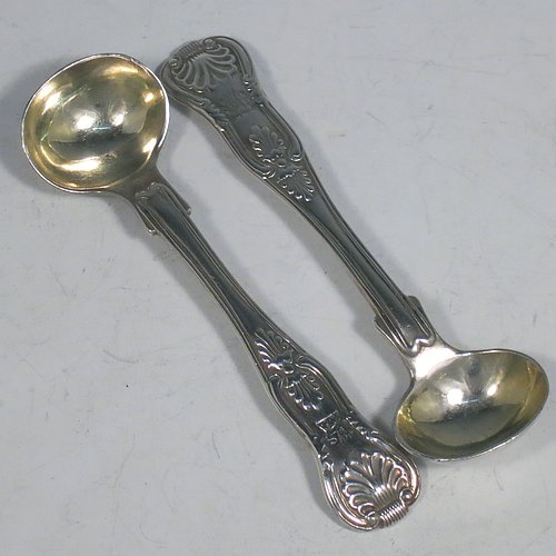 An Antique Georgian Sterling Silver pair of salt spoons, in the double-struck Kings pattern, having gold-gilt bowls. All made by William Traies of London in 1827. The dimensions of these fine hand-made antique silver salt spoons are length 11 cms (4.25 inches), and they weigh a total of approx. 90g (3 troy ounces). Please note that these salt spoons are crested.   