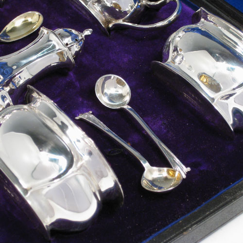    Antique Victorian sterling silver Art Nouveau seven-piece condiment service with spoons, all in original satin and velvet-lined presentation box. Consisting of four open salt cellars with gold-gilt interiors, two pepper pots with pull-off lids, and a single mustard pot with hinged lid and gold-gilt interior, together with four salt spoons and one mustard spoon with gold-gilt bowls. All made by James Round of Sheffield in 1897 (the condiment spoons are made by James Round in 1901). Length of mustard pot 9 cms (3.5 inches), height of pepper pots 9 cms (3.5 inches). Total weight approx. 13 troy ounces (403 g).