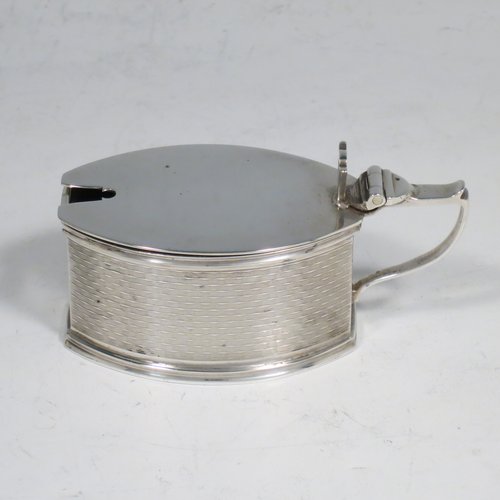 A Sterling Silver Art Deco condiment service, having oval straight-sided bodies with engine-turned decoration, with original blue-glass liners, pull-off lids on the peppers, hinged lids on the mustards, and all in original velvet and satin-lined presentation box. Consisting of two mustard pots, two pepper pots, two salt cellars, and four condiment spoons. Made in Chester and Birmingham from 1930 to 1934. Height of peppers 6.5 cms (2.5 inches), length of mustard 8 cms (3 inches), and a total weight of approx. 248g (8 troy ounces).   