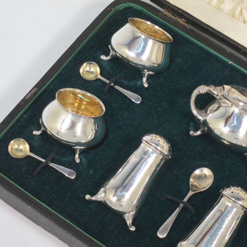 A pretty Antique Edwardian Sterling Silver seven-piece condiment service, having plain round bellied bodies, with gold-gilt linings for the salt cellars, pull-off lids on the peppers, a hinged lid on the mustard pot and original blue-glass liner, together with five condiment spoons, and all in their original dark green velvet and cream satin-lined presentation box. Consisting of one mustard pot, two pepper pots, four salt cellars, and five condiment spoons. All made by Charles Edwards of London in 1904 (apart from the mustard spoon which is hallmarked for 1934). The dimensions of this fine hand-made silver condiment set are height of peppers 6 cms (2.3 inches), length of mustard 6 cms (2.3 inches), and with a total weight of approx. 235g (7.6 troy ounces).    