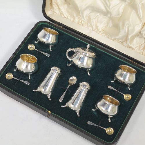 A pretty Antique Edwardian Sterling Silver seven-piece condiment service, having plain round bellied bodies, with gold-gilt linings for the salt cellars, pull-off lids on the peppers, a hinged lid on the mustard pot and original blue-glass liner, together with five condiment spoons, and all in their original dark green velvet and cream satin-lined presentation box. Consisting of one mustard pot, two pepper pots, four salt cellars, and five condiment spoons. All made by Charles Edwards of London in 1904 (apart from the mustard spoon which is hallmarked for 1934). The dimensions of this fine hand-made silver condiment set are height of peppers 6 cms (2.3 inches), length of mustard 6 cms (2.3 inches), and with a total weight of approx. 235g (7.6 troy ounces).    