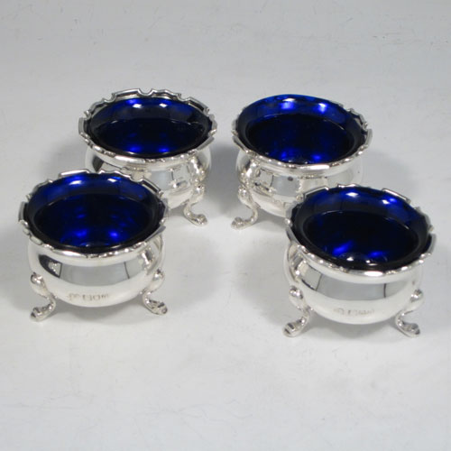 Antique sterling silver eight-piece condiment set, consisting of four open salt cellars with blue-glass liners, two mustard pots with hinged lids, and two pepper shakers, all with plain baluster round bodies, chippendale borders, and sitting on four cabriole legs, and all fitted into an original satin and velvet-lined presentation box. Made by Robert and William Sorely pf London in 1911. The dimensions of this fine hand-made silver condiment service are height of pepper pots 7 cms (2.75 inches), length of mustard pots 7 cms (2.75 inches), and with a total weight of approx. 252g (8 troy ounces). 
