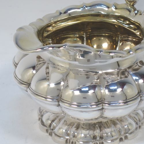 A very pretty Antique late Georgian Sterling Silver large cream jug, having a lobed round  body with hand-chased melon fluting, a scroll top border, a scroll handle with thumb-piece, a gold-gilt interior, and all sitting on a matching pedestal foot. Made by the Barnard Brothers of London in 1829. The dimensions of this fine hand-made antique silver cream jug are height 12 cms (4.75 inches), length 16 cms (6.25 inches), and it weighs approx. 233g (7.5 troy ounces).  