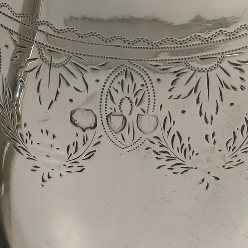 A pretty Antique Victorian Sterling Silver cream jug, having a round bellied body with hand-engraved  floral decoration, an applied reeded border and reeded scroll handle, all sitting on a flat base. This beautiful antique silver cream or milk jug was made in London in 1890. The dimensions of this fine hand-made antique silver cream jug are height 9 cms (3.5 inches), length 11 cms (4.25 inches), and it weighs approx. 82g (2.6 troy ounces).  