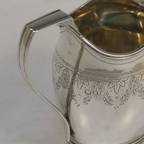 A pretty Antique Victorian Sterling Silver cream jug, having a round bellied body with hand-engraved  floral decoration, an applied reeded border and reeded scroll handle, all sitting on a flat base. This beautiful antique silver cream or milk jug was made in London in 1890. The dimensions of this fine hand-made antique silver cream jug are height 9 cms (3.5 inches), length 11 cms (4.25 inches), and it weighs approx. 82g (2.6 troy ounces).  