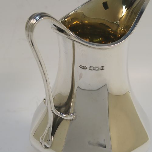 An elegant Antique Sterling Silver cream jug, in an Art Nouveau style having a plain panelled and bellied body, a scroll side-handle, a sparrow-beak spout, a gold-gilt interior, and sitting on four cast and pierced feet. This beautiful silver cream jug was made by Charles Clement Pilling of Sheffield in 1922. The dimensions of this fine hand-made antique silver cream jug are height 12.5 cms (5 inches), length 10 cms (4 inches), and it weighs approx. 210g (6.8 troy ounces).   