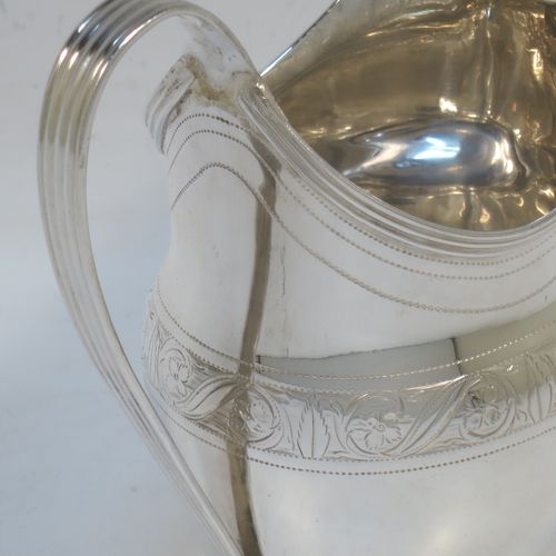 A very elegant Antique Georgian Sterling Silver cream jug, having a round bellied body with hand-chased bands of stipple and floral work, an applied reeded border and reeded scroll handle, and all sitting on a flat base. Made George Burrows of London in 1800. The dimensions of this fine hand-made antique silver cream jug are height 11 cms (4.25 inches), length 11.5 cms (4.5 inches), and it weighs approx. 101g (3.3 troy ounces).   