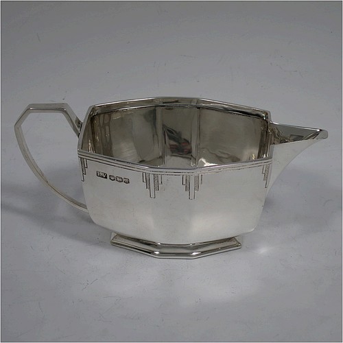 A very handsome Art Deco Sterling Silver cream jug, having a plain panelled rectangular body, a sparrow-beak spout, a cast angular handle, an applied top border with hand-engraved reeding and Deco style decals, and sitting on a collet foot. Made by Emile Viner of Sheffield in 1940. The dimensions of this fine hand-made Art Deco silver cream jug are height 7 cms (2.75 inches), length 15.5 cms (6 inches), width 7.5 cms (3 inches), and it weighs approx. 198g (6.4 troy ounces).    