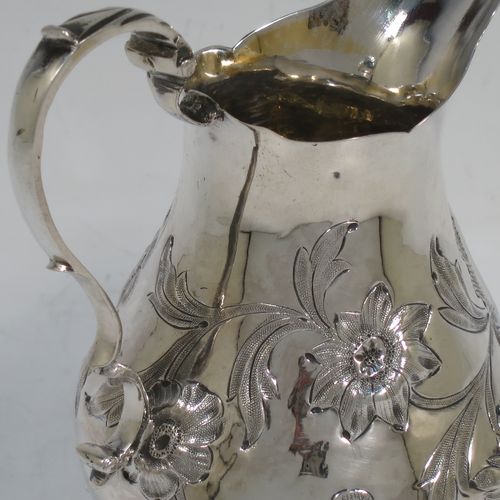 A very pretty Antique early Victorian Sterling Silver cream or milk jug having a round bellied body with hand-chased floral decoration surrounding a vacant cartouche, a scroll handle with anthemion leaf thumb-piece, a shaped border with a spout, a gold-gilt interior, and sitting on three cast trefoil feet. Made by William Hunter of London in 1845. The dimensions of this fine hand-made antique silver cream jug are height 11.5 cms (4.5 inches), length 10 cms (4 inches), and it weighs approx. 115g (3.7 troy ounces).    