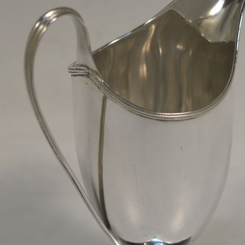 A handsome Antique Georgian Sterling Silver milk or cream jug, having a round body with tapering sides in a Helmet style, with an applied reeded border, a reeded looped handle, and sitting on a pedestal foot with a square base. This elegant antique silver cream or milk jug was made by Stephen Adams I of London in 1794. The dimensions of this fine hand-made antique silver cream jug are length 11 cms (4.3 inches), height 15.5 cms (6 inches), and it weighs approx. 112g (3.6 troy ounces).  