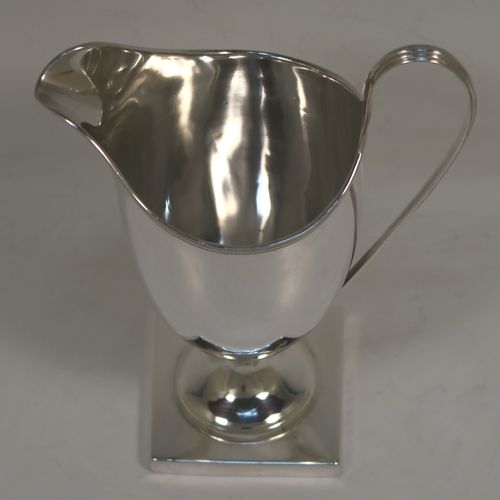 A handsome Antique Georgian Sterling Silver milk or cream jug, having a round body with tapering sides in a Helmet style, with an applied reeded border, a reeded looped handle, and sitting on a pedestal foot with a square base. This elegant antique silver cream or milk jug was made by Stephen Adams I of London in 1794. The dimensions of this fine hand-made antique silver cream jug are length 11 cms (4.3 inches), height 15.5 cms (6 inches), and it weighs approx. 112g (3.6 troy ounces).  