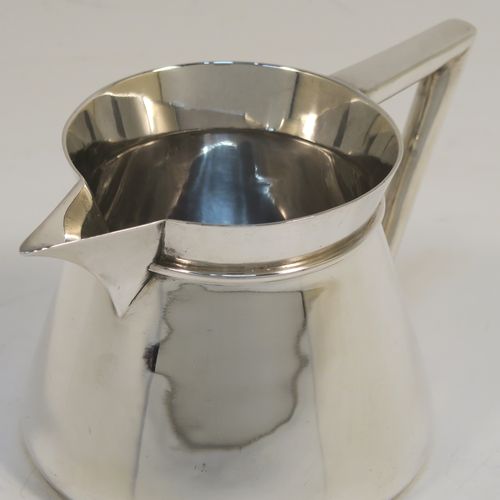 An unusual Arts and Crafts style Antique Sterling Silver cream jug, having a plain round body with tapering sides, an angular side-handle, a sparrow-beak spout, and sitting on a flat base. This beautiful silver cream jug was made by Pearce and Sons of Sheffield in 1913. The dimensions of this fine hand-made antique Arts and Crafts silver cream jug are height 7 cms (2.75 inches), length 13.5 cms (5.25 inches), and it weighs approx. 168g (5.4 troy ounces).  