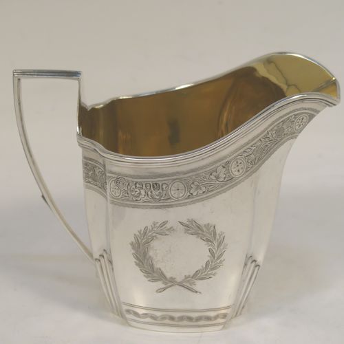 A very pretty Antique Victorian Sterling Silver milk or cream jug, having a panelled oval mainly straight-sided body, with hand-engraved bands of floral decoration, and hand-chased half-fluted corners, a gold-gilt interior, an applied reeded border, a scroll handle with flat top, and sitting on a flat base. This beautiful antique silver cream or milk jug was made by J. B. Carrington of London in 1887. The dimensions of this fine hand-made antique silver jug are height 10 cms (4 inches), length 12.5 cms (5 inches), and it weighs approx. 137g (4.4 troy ounces).  